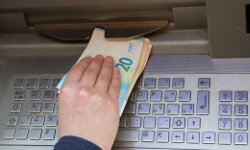 Jugendlicher hebt Geld am Automaten ab